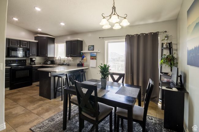 Dining room featuring light tile patterned flooring, recessed lighting, and an inviting chandelier | Image 7