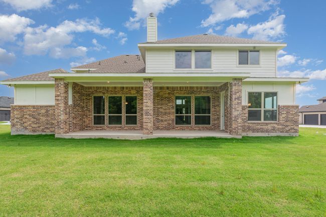 Back of house with a patio, brick siding, a chimney, a lawn, and a shingled roof | Image 15