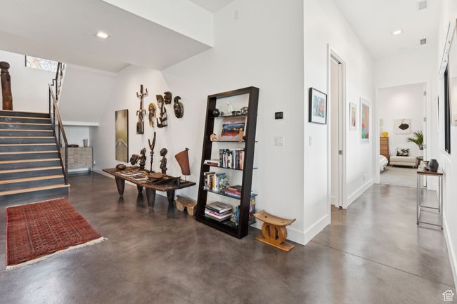 Corridor with finished concrete floors, stairs, and recessed lighting | Image 58
