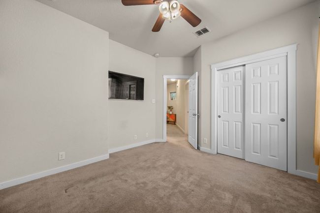 Unfurnished bedroom featuring light carpet, baseboards, a closet, and ceiling fan | Image 25