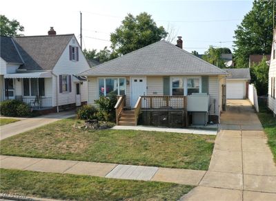 View of front of property featuring a garage, an outdoor structure, and a front yard | Image 3