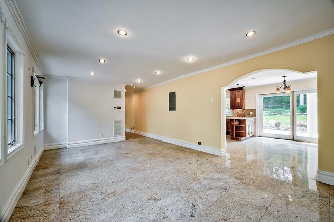 Empty room featuring electric panel, baseboards, arched walkways, crown molding, and recessed lighting | Image 7