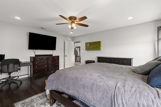 Bedroom with freestanding refrigerator, wood finished floors, recessed lighting, and ceiling fan | Image 19