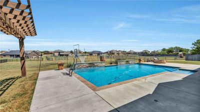 View of swimming pool with a lawn and a patio | Image 3