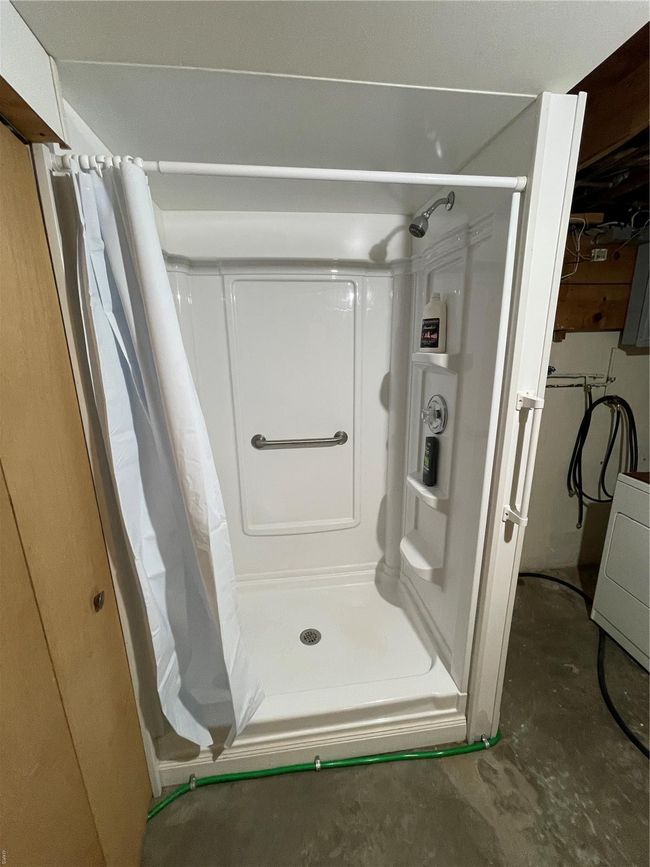 Full bath with washer / dryer, concrete flooring, and a stall shower | Image 36