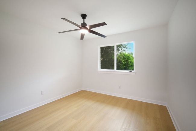 Empty room with a ceiling fan, light wood-style floors, and baseboards | Image 18