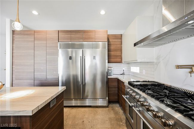 Kitchen featuring tasteful backsplash, wall chimney exhaust hood, modern cabinets, high end appliances, and recessed lighting | Image 17