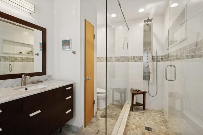 Full bathroom with tile walls, vanity, a stall shower, toilet, and recessed lighting | Image 9