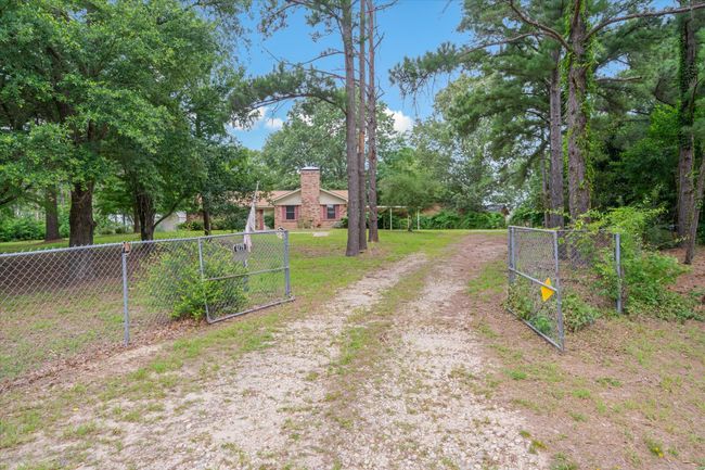 View of dirt / gravel road with a gate and a gated entry | Image 33