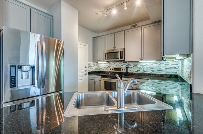 Kitchen featuring stainless steel appliances, rail lighting, gray cabinetry, and backsplash | Image 17