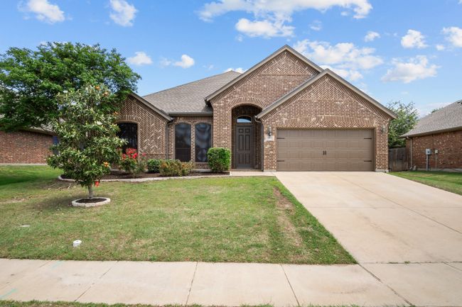 View of front of home with concrete driveway, brick siding, an attached garage, and a front lawn | Image 29