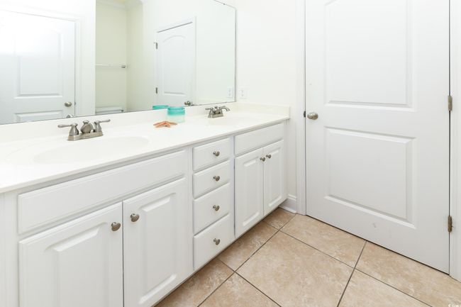 Bathroom featuring double vanity, tile patterned flooring, and a sink | Image 10