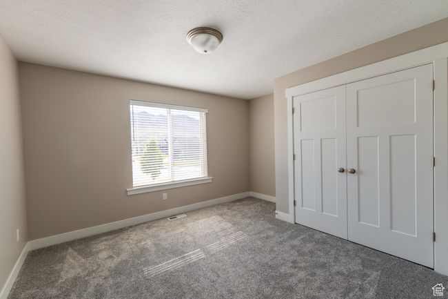 Unfurnished bedroom with carpet flooring and a closet | Image 6