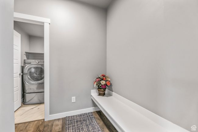 Clothes washing area with washer / dryer, wood finished floors, laundry area, and baseboards | Image 18