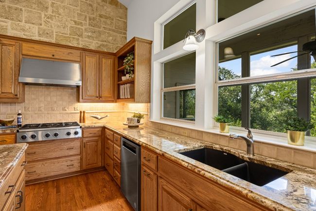 The meticulously maintained drop-in Dacor gas range adds premium performance to the kitchen, while custom cabinetry offers both storage and elegant display space for your favorite dishes. | Image 14