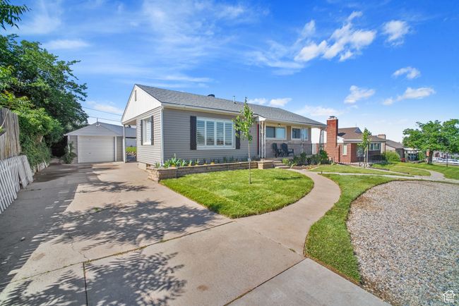 View of front of home featuring an outdoor structure, a garage, a front yard, and concrete driveway | Image 33