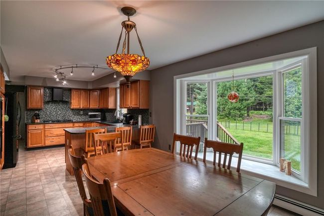 Dining room with a healthy amount of sunlight, sink, and baseboard heating | Image 15