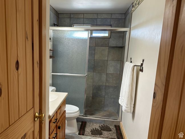 Full bathroom featuring baseboards, toilet, vanity, tile patterned flooring, and a stall shower | Image 19