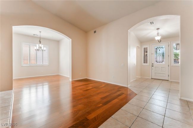 Entryway featuring arched walkways, a chandelier, baseboards, and light tile patterned floors | Image 23