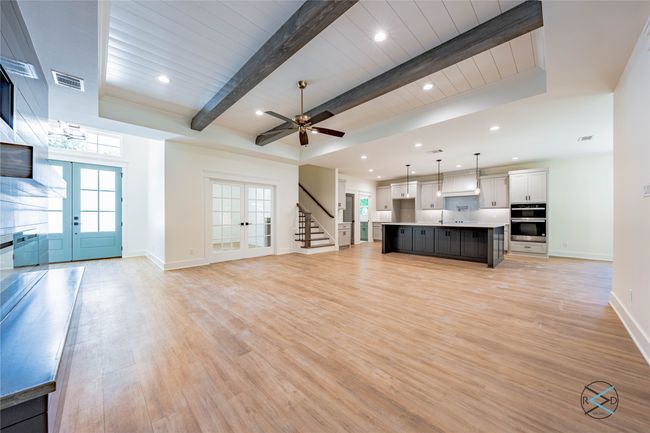 Unfurnished living room with french doors, light wood-type flooring, and beamed ceiling | Image 4