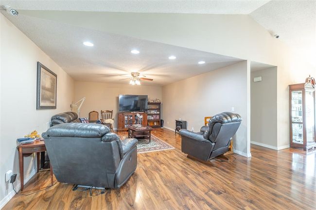 Living room with wood finished floors, ceiling fan, recessed lighting, baseboards, and high vaulted ceiling | Image 17