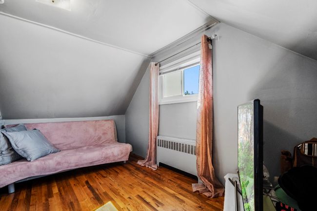 Additional living space featuring radiator, vaulted ceiling, and wood finished floors | Image 13