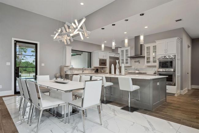 The dining room seamlessly flows into the kitchen, creating an open and spacious feel, enhanced by soaring ceilings throughout. | Image 12