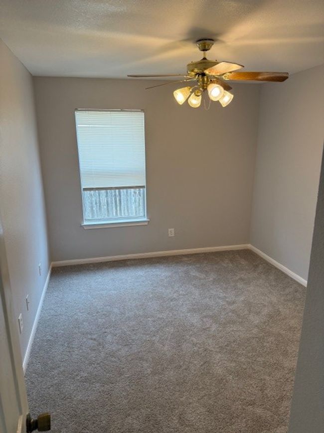 Carpeted empty room with ceiling fan and baseboards | Image 13