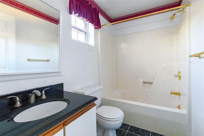 Full bathroom featuring toilet, tile flooring, vanity, and tub / shower combination | Image 22