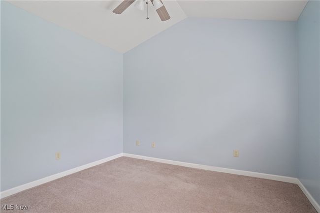 Unfurnished room with carpet floors, a ceiling fan, lofted ceiling, and baseboards | Image 7