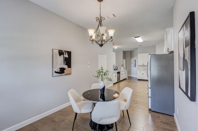 Dining space featuring a chandelier, wood finished floors, and baseboards | Image 12