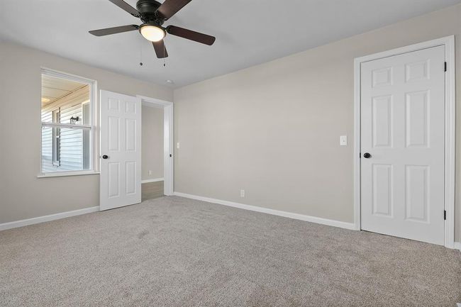 Unfurnished bedroom featuring carpet flooring, baseboards, and a ceiling fan | Image 15