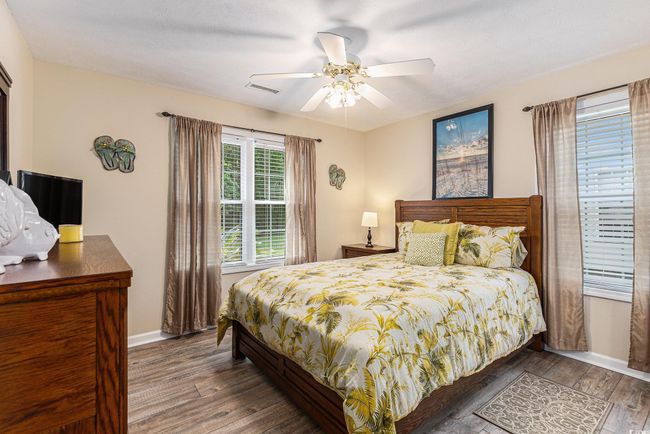 Bedroom featuring wood finished floors, baseboards, and a ceiling fan | Image 24