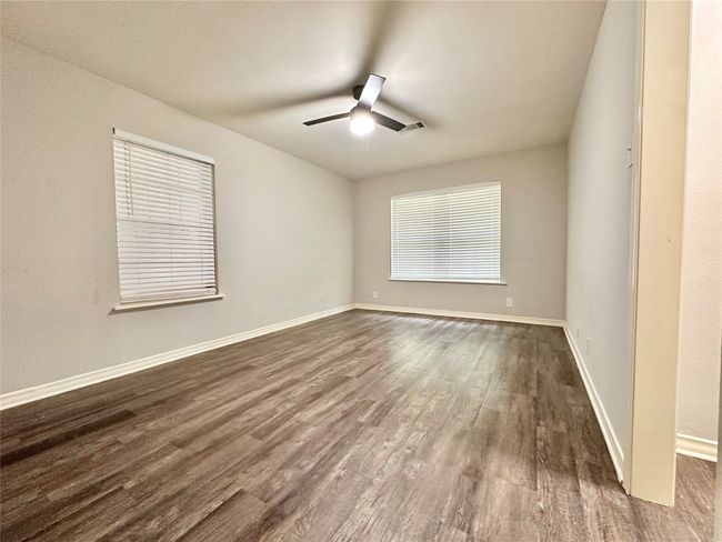Spare room featuring dark wood-style floors and a ceiling fan | Image 17
