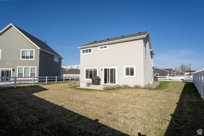 Rear view of property with a fenced backyard, stucco siding, and a lawn | Image 21