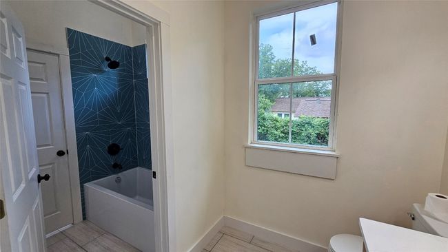 Bathroom featuring toilet, baseboards, shower / bathtub combination, tile patterned flooring, and vanity | Image 9