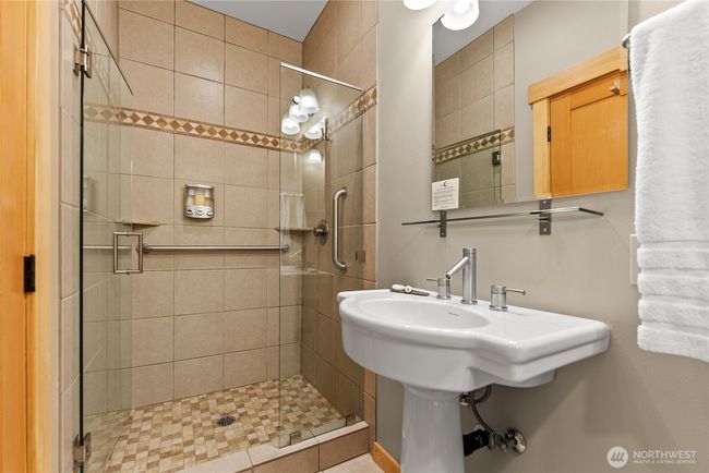 3/4 bathroom with tiling and safety bars off of Unit A bedroom. | Image 31