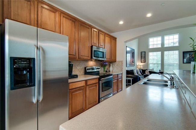 Kitchen with appliances with stainless steel finishes, sink, and backsplash | Image 6