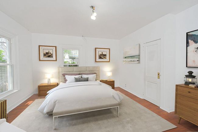 Bedroom with wood finished floors and radiator heating unit | Image 15