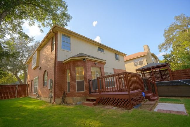 Back of house featuring brick siding, a wooden deck, and a gazebo | Image 23