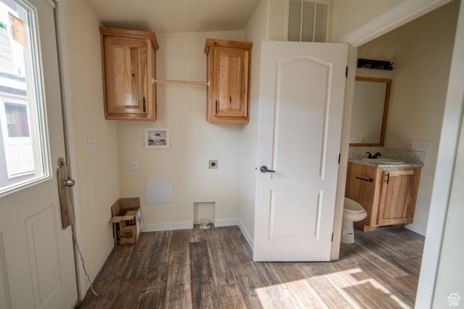 Laundry area with electric dryer hookup, wood finished floors, visible vents, and washer hookup | Image 19