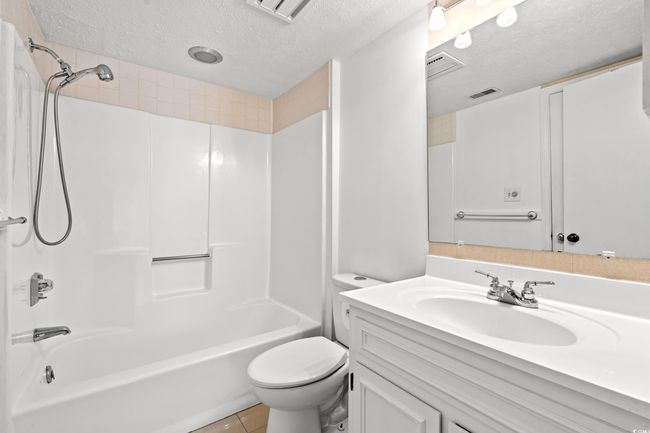 Bathroom featuring a textured ceiling, vanity, shower combination, and tile patterned flooring | Image 15