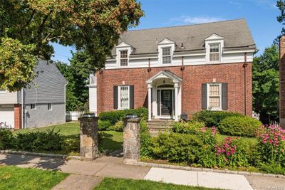 View of front of home featuring stone pillars and native landscaping | Image 1