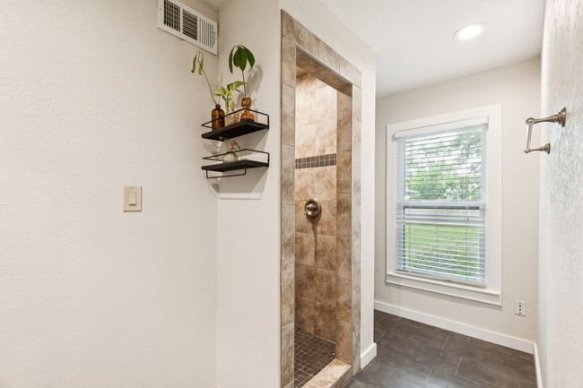 Ensuite bathroom with double vanity, a tile shower, and an oversized walk in closet. | Image 19