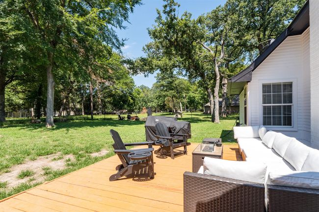 Wooden terrace featuring a grill, a yard, and an outdoor living space with a fire pit | Image 22