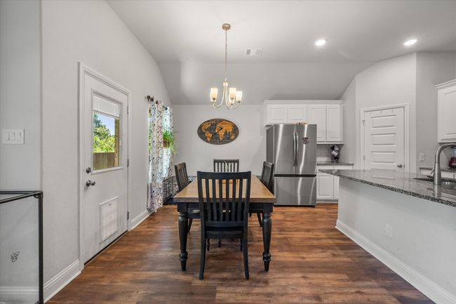 Dining room featuring a chandelier, vaulted ceiling, dark wood-style floors, and recessed lighting | Image 10