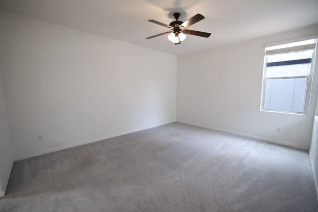 The primary suite is a peaceful retreat with cozy carpeting and its own ensuite bathroom with a walk-in closet. | Image 11