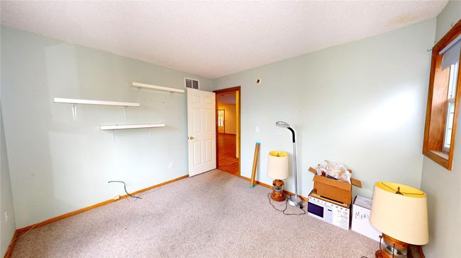Miscellaneous room with visible vents, carpet flooring, a textured ceiling, and baseboards | Image 19