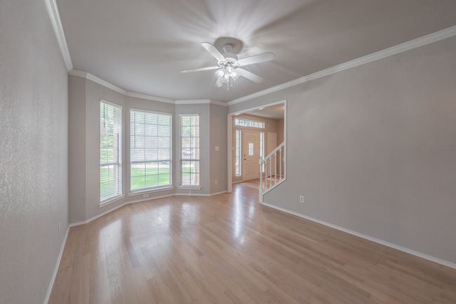 Formal living room featuring beautiful wood floors, bay window and crown molding. | Image 8