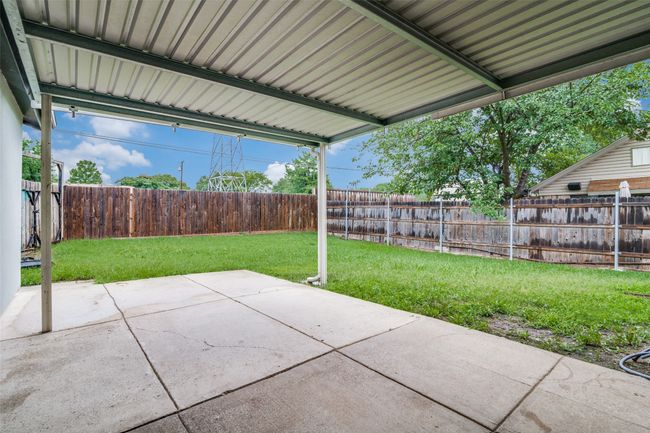 Fenced backyard with a patio | Image 24